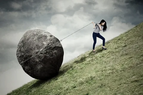 a girl facing an issue in moving a rock